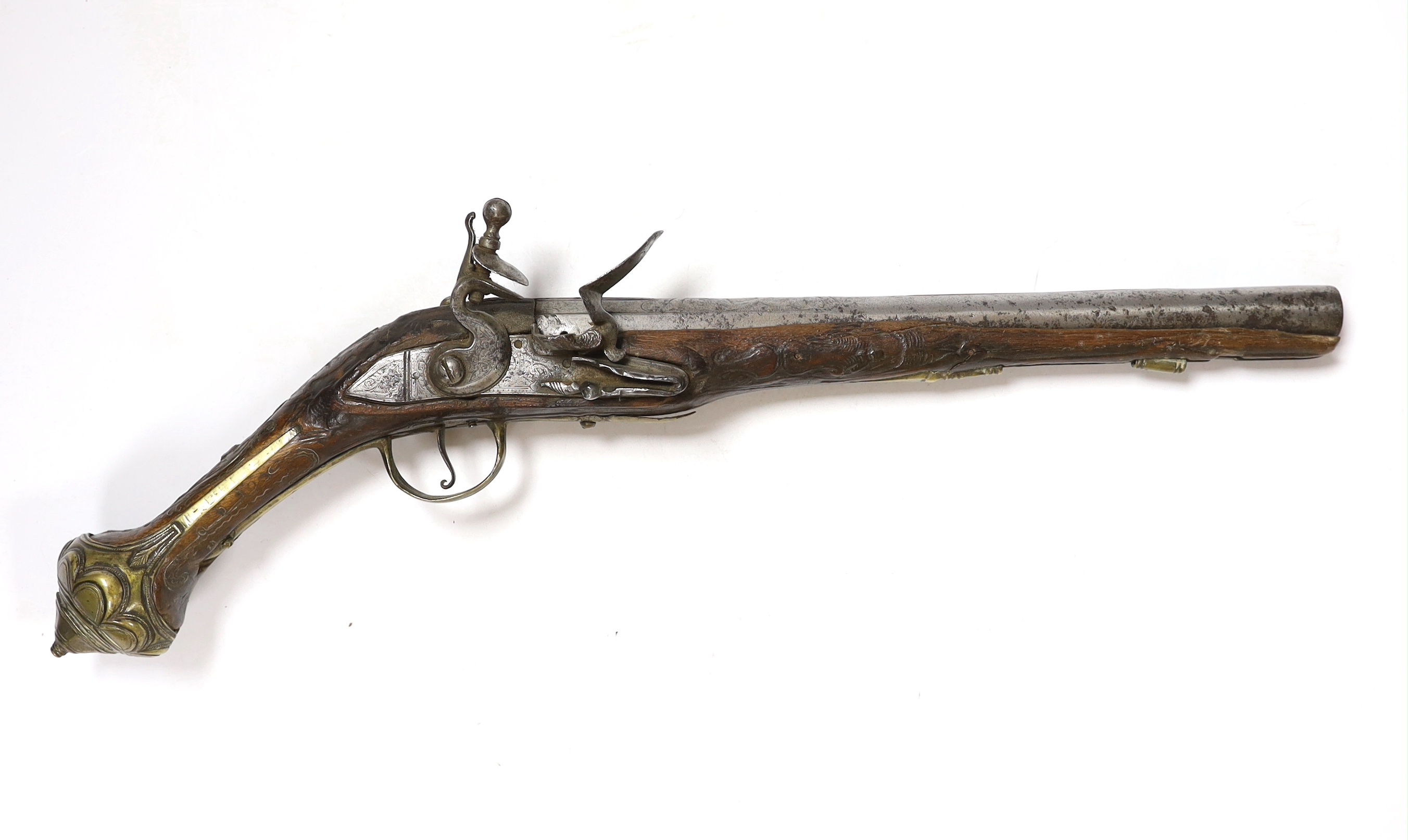 A Turkish Flintlock holster pistol with brass mounts, long spur butt cap, engraved lock and carved stock, barrel 29.5cm